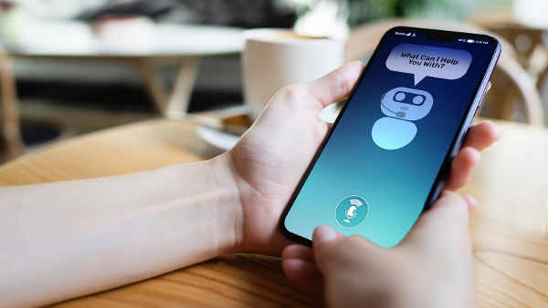 Une personne tenant un smartphone qui a un chatbot en direct sur l'écran du téléphone.
