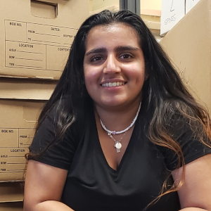 Young woman kneeling in front of moving boxes