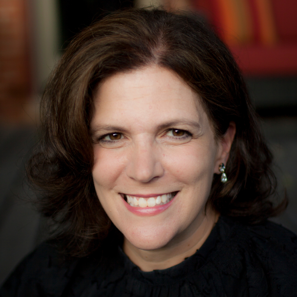 Woman with chin-length brown hair, smiling at camera