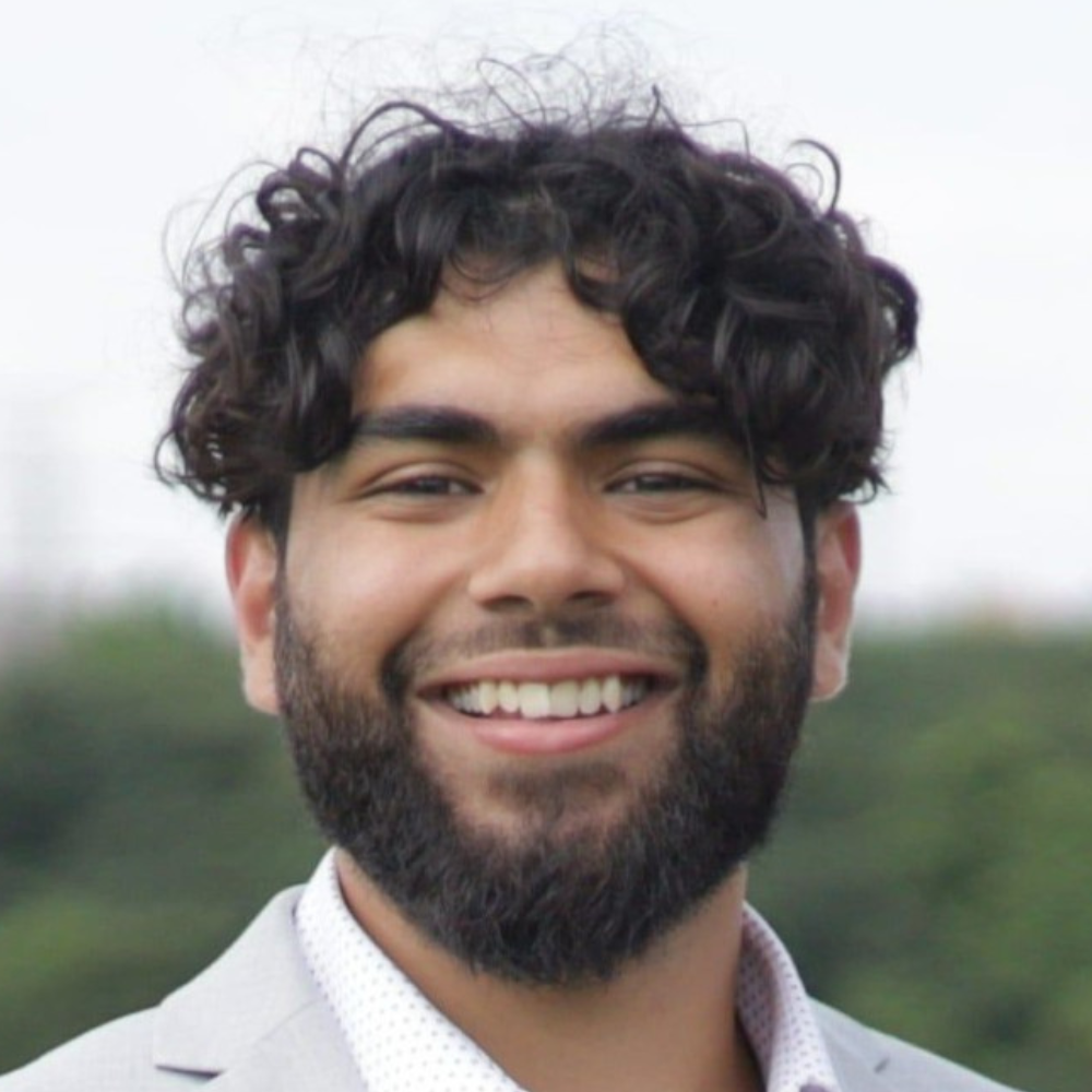 Young man with dark curly hair and closely-trimmed beard