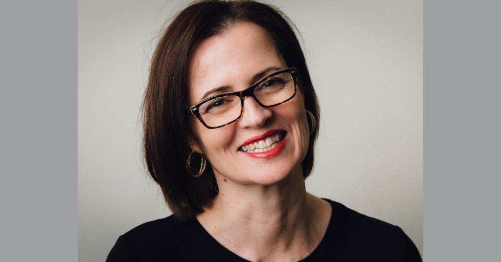 Woman with shoulder length dark brown hair and dark brown glasses