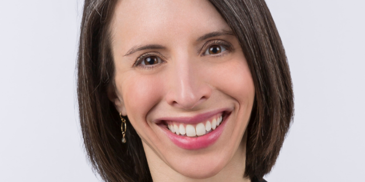 Woman with chin length black hair and a broad smile