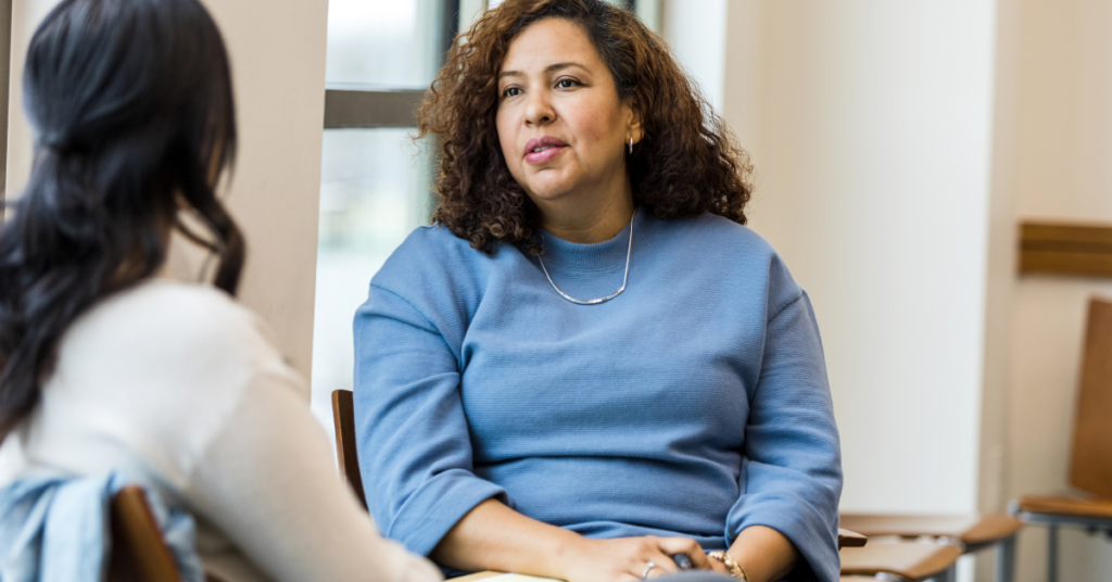 Two women sitting across from each other, talking